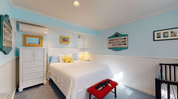 A crib set up beside the bed in the same room.