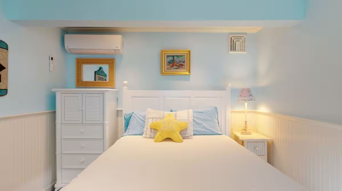 A bedroom in Crew with a made bed and a starfish motif.