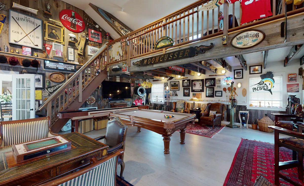 The barn looking the other way from the card table, past the pool table to the television wall, with the loft staircase on the left and glazed doors through to the house